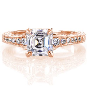 The mesmerizing step-cut facets of the 1.00 carat asscher cut center diamond seem to cascade on forever and create a stunning focal point for this design. The band has bead set diamonds on top along with hand engraving. The sides feature hand engraving, delicate filigree, and surprise diamonds. 