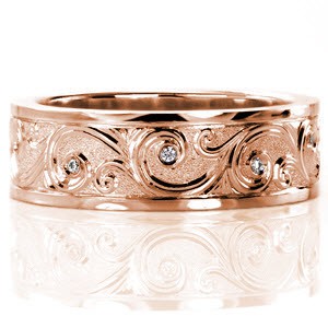 Continual scrolls grace the surface of Design 2487. The unique hand engraved style displays a raised relief in which each of the scroll designs are higher than their background. Perfectly placed round cut diamonds are flush set within the larger curls.