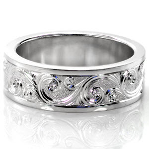 St Louis custom wide band ring with high polished rails bordering a central scroll style hand engraving pattern with bezel set diamonds and a sandblasted background.