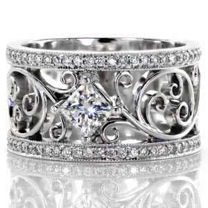 This magnificent ring incorporates a unique free flowing filigree design that is truly eye catching. The design is framed on either side by a row of micro pavé diamonds with a 0.50 carat princess cut diamond in the center. The filigree pattern is enthralling with a sense of movement, a truly stunning design.