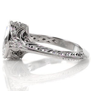 Indianapolis custom antique inspired engagement ring with a hand engraved knife edge band leading to an oval cut diamond center held in a full bezel.