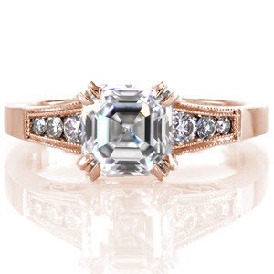 This elegant design features a 1.73 carat asscher cut center diamond in a double prong setting. The tapered band has channel set round diamonds on either side of the center stone and micro pavé on the prongs. There are stunning handmade filigree curls visible from the side profile of this ring.