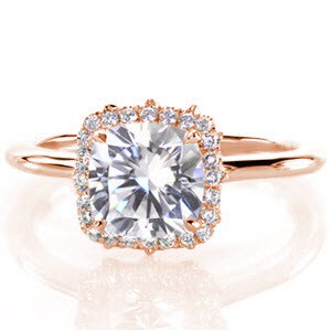 Our Jasmine design features a 1.50 carat center stone delicately set within four prongs. The square halo holds diamonds set in the French style with tiny hand cut double prongs. The piece is dramatically uplifted by a marquise shaped pierced design that proudly holds the halo in place.