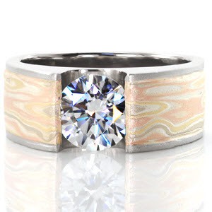 The artistry of our Solstice-Autumn Wind ring is astounding. A beautiful mixed-metal Mokume Gane inlay in rose, yellow and white make this ring truly breathtaking. The simplistic and contemporary look of the wide mounting design elegantly displays the round brilliant cut diamond in a channel setting.