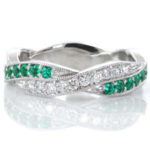 This hypnotic design features a woven pattern where luscious green emeralds intertwine with vibrant white diamonds. All the beautiful gemstones are securely set with shared, bead-set prongs and fashioned in a platinum band. Each segment is edged with a beaded milgrain texture that adds a refined finish to the piece.