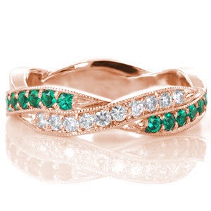 This hypnotic design features a woven pattern where luscious green emeralds intertwine with vibrant white diamonds. All the beautiful gemstones are securely set with shared, bead-set prongs and fashioned in a platinum band. Each segment is edged with a beaded milgrain texture that adds a refined finish to the piece.
