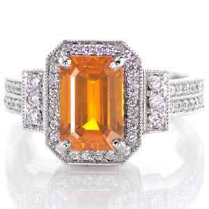 Vibrant hues from the 2.00 carat emerald cut orange sapphire make this ring stand alone. Set in a 14k white gold art deco band with classic prongs, the sapphire takes center stage. All edges are adorned with milgrain detail to frame the round cut bead set diamonds for a delicate touch.