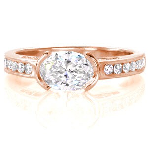 The Oval Novara is uniquely designed with a 0.75 oval center cut diamond set in a horizontal half-bezel. The high polished 14k white gold band is channel set with many round diamonds. This looks stunning with the added touch of perfectly placed hand wrought filigree.