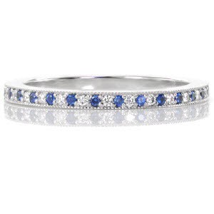 This delicate band features .12 carats of alternating royal blue sapphires and glimmering white diamonds. Each stone is perfectly set by hand in a traditional bead setting. The band is finished with milgrain detail creating a lovely beaded texture framing the design.  