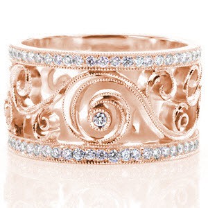 Unique wedding rings in St. Petersburg are hand crafted in rose gold. This beautiful wide wedding band is uniquely vintage inspired and features flowing filigree curls set with diamonds. The micro pave rails add brilliance to the design.
