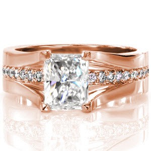 Design 2636 blends contemporary styling, a bold shank and angular prongs with structured ease. Crafted in 14k white gold, the 0.30 radiant cut center diamond is raised up from the shank as a line of round cut diamonds flow underneath. Round surprise diamonds are on both ring faces.