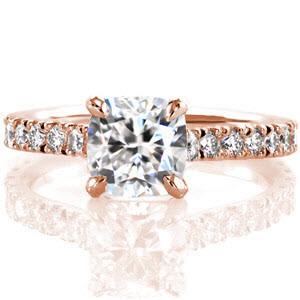A design of simple elegance, Design 2639 features an eye-catching 1.00 carat cushion cut center diamond. The band is dazzling with its micro pavé and from the sides you can see that the band and side stones gracefully curve upward to meet the center stone.