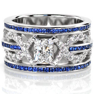 The blue sapphires add a breathtaking pop of color to this signature wide band. The stunning 0.50 carat radiant cut diamond is securely fashioned in 4-prong setting in the center of the design. Micro pavé are seamlessly interwoven along the middle row of sapphires drawing the eye to the brilliant radiant. 