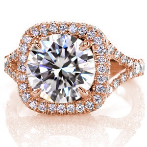 The 3.00 carat round brilliant is magnified with a halo of micro pavé stones. The side profile of the halo is adorned with diamonds to heighten the fire and sparkle of this U-cut platinum design. The split shank meets and larger round stones seamlessly continue down the band for a regal touch.