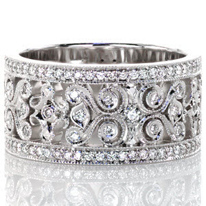 Caledonia Petite is a brilliant display of pierced filigree scrolls and micro pavé diamonds. The wide 14k white gold band presents a significant display with two outer bands of round cut micro pavé diamonds. Within the bands, the open spaces and milgrain edging highlight the filigree design.