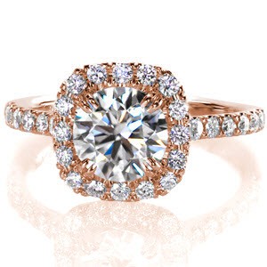 Round brilliant diamonds shine from every angle of this design. Hand formed u-cuts minimize the metal holding the stones while securely fashioning the stones, giving this ring maximum sparkle. Micro pavé diamonds surround the round center in a cushion shaped halo.   