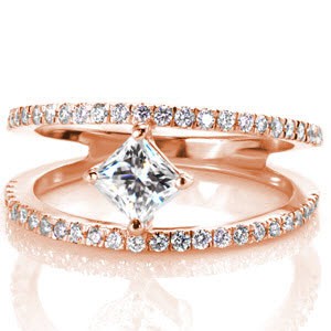 A kite-set princess cut diamond makes a unique focal point to the center of this split-shank engagement ring. Design 2817 is a striking contemporary ring handcrafted in 14k white gold. Dazzling round brilliant diamonds line the outside bands enhancing the shine and radiance of this custom design.
