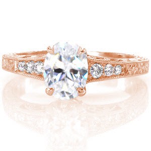 Ferrara is a vintage inspired ring currently featuring a 1.00 carat oval cut center diamond. The flared band is ornately decorated with relief hand engraved designs, and hand formed filigree curls. The relief engraving has floral inspiration on the top of the band, and elegant scroll work on the sides.