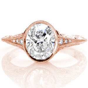 This exceptional, antique inspired, engagement ring features a 2.00 carat oval center diamond crowning an ornately detailed knife edge band. The sides reveal hand carved relief engraving and hand formed filigree. The carefully stippled background of the engraving adds contrast and highlights the scroll pattern.