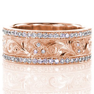 This custom wide band is elegantly enhanced with leaves and swirls of relief hand engraving. The leaves are set with small round diamonds and the edges are outlined with milgrain. The background is stippled to provide contrast from the high polish of the swirl pattern.