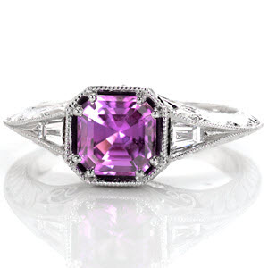 The milgrain knife edge flares to the top of the ring to meet the decorative octagon setting. The asscher cut purple sapphire is fashioned in a double prong on each corner. Tapered baguettes accent the split of the knife edge on either side of the center. Filigree, hand engraving and round diamonds adorn the sides. 