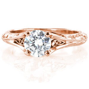 Custom engagement ring in Victoria with a hand engraved knife edge band and filigree curls bordering the center diamond.
