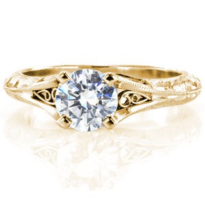Custom engagement ring in Columbia with a hand engraved knife edge band and filigree curls bordering the center diamond.