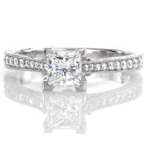 The Princess Vera is an exquisite antique inspired design that features a 0.75 carat princess cut in chevron prongs. Hand engraving, filigree, and milgrain adorn the sides of the ring for a vintage appeal. Micro pavé diamonds graduate in size along the band, giving brilliance and shine to the white gold metal.