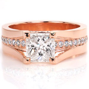 This cathedral style engagement ring is a regal custom design. The 1.25ct princess cut center diamond is set high enough so a row of bead set round diamonds can go completely under the center stone. More small diamonds adorn the sides of the band between the prongs for added effect. This ring is shown in 14k rose gold.