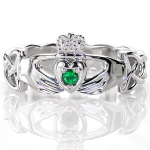 Crafted in 14k white gold, our Claddagh ring joins a trinity of Celtic heritage. A round cut natural emerald is captured by the heart. Two reaching hands represent friendship and the milgrain adorned crown represent loyalty. With a high polish finish, the woven Celtic knot band is pierced near the hands.
