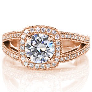 This regal, antique inspired design features a round brilliant cut center diamond surrounded by a cushion shaped halo. The band is a split shank with cast-in-place engraving, and hand formed filigree. The top of the band and both parts of the halo are detailed with brilliant micro pave
