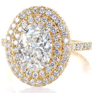 Design 3004 is a statement ring that boldly displays a 2.00 carat Oval cut diamond.  Meticulous placed within unique U-Cut prongs and bead set, a halo of two rows are completely adorned with round cut diamonds.  Crafted in 14k yellow gold, the band also has U-Cut prongs and an open gallery.