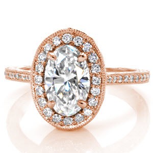A meeting of elegant and vintage, this design features a haloed 1.20ct oval cut diamond atop a petite micro pavé band. Intricate scroll relief engraving frames the band and highlights the basket, which holds a tapestry of arched diamonds, filigree and two marquise surprise diamonds.