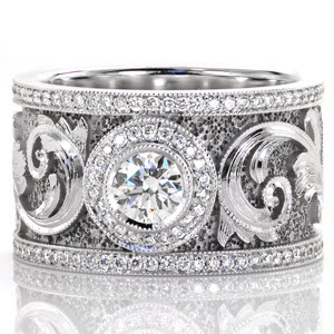 An elegant motif drapes across this signature band. A 0.50 carat bezel set center is accented with a micro pavé halo. The scroll work along the band is magnificent with hand engraved detail and faceted stipple background that captures the light. Two rows of milgrained micro pavé diamonds frame the design. 