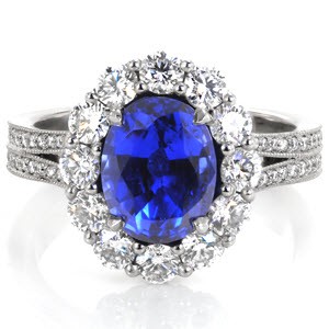 This vintage-inspired design is mesmerizing with a 2.20 carat oval cut blue sapphire surrounded by a dazzling halo. This intricate design is adorned with micro pavé diamonds leading down its split shank. The side profile reveals a beautifully crafted  basket with micro pavé embellishments.