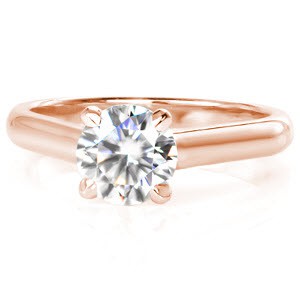 Elegant and streamlined, this solitaire ring features a 0.70 carat round brilliant cut diamond in a four-prong cathedral setting. The hand-formed filigree curls revealed on its side profile gives an artistic detail to an otherwise timeless and classic design.