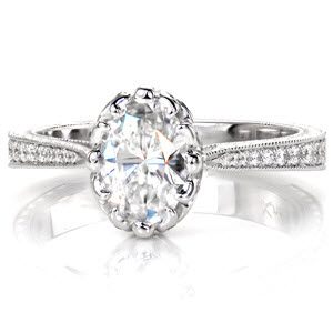 Design 3048 is an exquisite ring with a unique central prong setting featuring a 0.80 carat oval cut stone. The side profile of this piece reveals pierced elements and hand formed filigree curls that highlight the diamond. Graduated diamonds and hand engraving detail the tapered band.