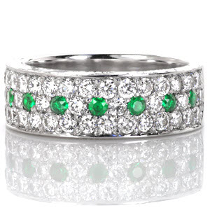 Design 3057 is paved with long rows of diamonds and gemstones. The micro pavé setting features two rows of stunning round brilliants with a single row of alternating diamonds and luscious green emeralds in between. The sides of this band are detailed with captivating hand engraved designs. 