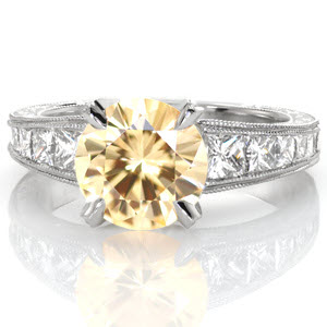Showcasing an extraordinary 2.39 carat round yellow sapphire, design 3097 is the definition of luxury. This platinum setting's elegant bead-set diamond prong join with a tapering band featuring channel set princess cut diamonds, mil-grain edges and scroll hand engraving.