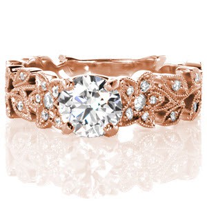 Design 3123 unites a 0.90 carat round brilliant diamond center with an exquisitely detailed floral motif band. Flower petals and leaves alike are all accented with micro pavé diamonds and edged with a milgrain texture, giving this ring a truly stunning vintage flair.