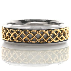 Interwoven strands of yellow gold creates a distinct Celtic pattern down the center of this eternity band. The white gold background has a sandblasted finish giving contrast and dimension to the polished Celtic pattern. Beveled edges frame the design and provides a comfortable fit.  