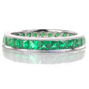 The Birthstone Eternity Band features lush princess cut emeralds that continue around the entire ring for a seamless finish. The emeralds are channel set within a band of high polished 14 karat white gold. The finest quality hand-applied milgrain detail finishes the band outer edges.