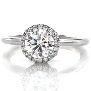 The classic style of our Jasmine Round design displays a 1.00 carat center stone within four prongs. The halo sets round diamonds in French style hand cut double prongs adding to a vintage look. The setting profile provides dramatic elegance with a pierced basket.