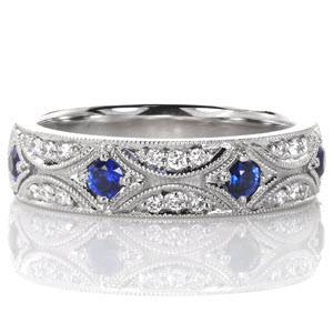 Denver unique wedding bands with hand engraving and micropave diamonds. This vintage style wedding band features a star burst pattern decadently set with diamonds and rich blue sapphires. Milgrain edging really captures the antique feel of the design.