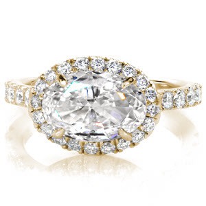Custom engagement ring in Calgary with a unique horizontal set oval cut center diamond surrounded by a diamond halo and band.