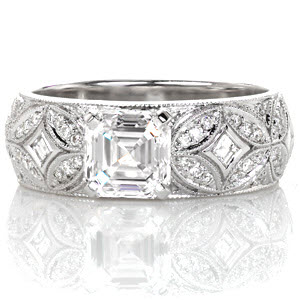 Perfectly interlacing features of carre cut diamonds bezel set around marquise-shape arches produces a stunning antique pattern in Design 3234. Micro pavé diamonds and milgrain edges lavishly detail the ring. The step-cut facets of the 1.00 carat asscher cut creates a stunning focal point to this wide band design.