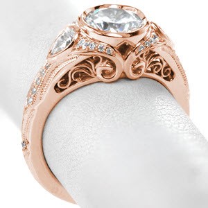 Filigree engagement ring in Buffalo with round center stone and pear side stones.