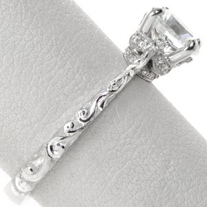 Unique antique engagement ring in Los Angeles features stunning relief style hand engraving on the band with a crown-like basket under the center stone. This regal center setting is adorned with micro pave diamonds. 