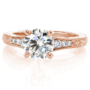 Design 3248 offers a modern look with vintage inspired details. A 1.50 carat round brilliant center is surrounded by bead-set side diamonds and floral hand engraving extends down the band. Its raised cathedral profile includes relief engraving and hand wrought filigree curls. Milgrained edges add the final refinement.