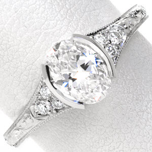 Antique engagement ring in Boston with half bezel oval center stone, hand engraving, and filigree.
